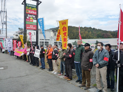横断幕やのぼりを持って沿道に並ぶ支援の仲間
＝11月５日、山梨県富士吉田市・富士急本社前